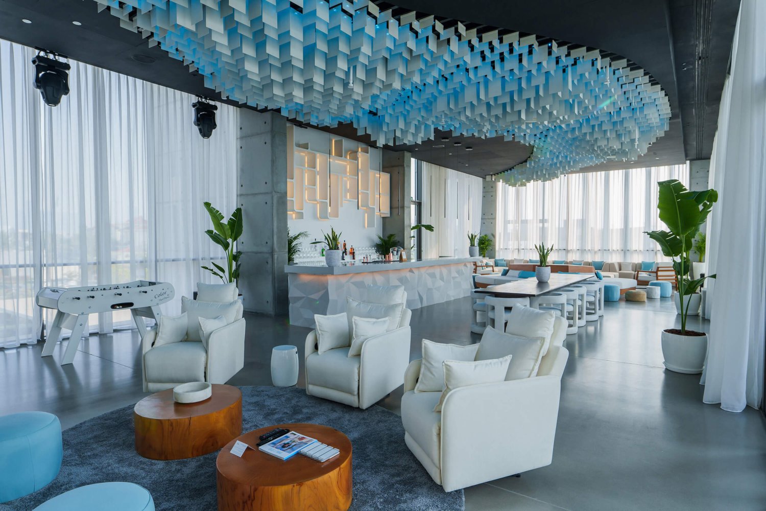 Celebration Suite Living Room Lounge with various seating areas, a bar and a foosball table