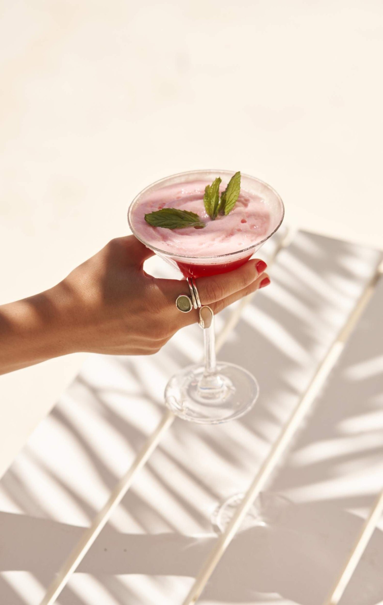 A strawberry daiquiri cocktails garnished with mint