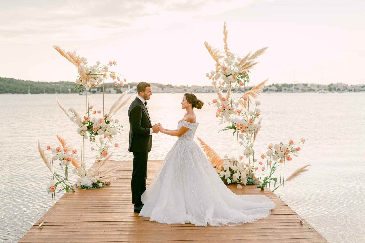 A man and women getting married on a wooden walkway in the sea
