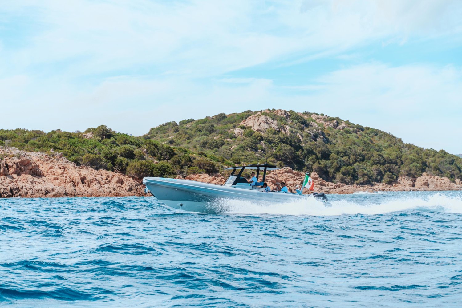 Close up of A small jet boat sailing in the sea with mountains in the background