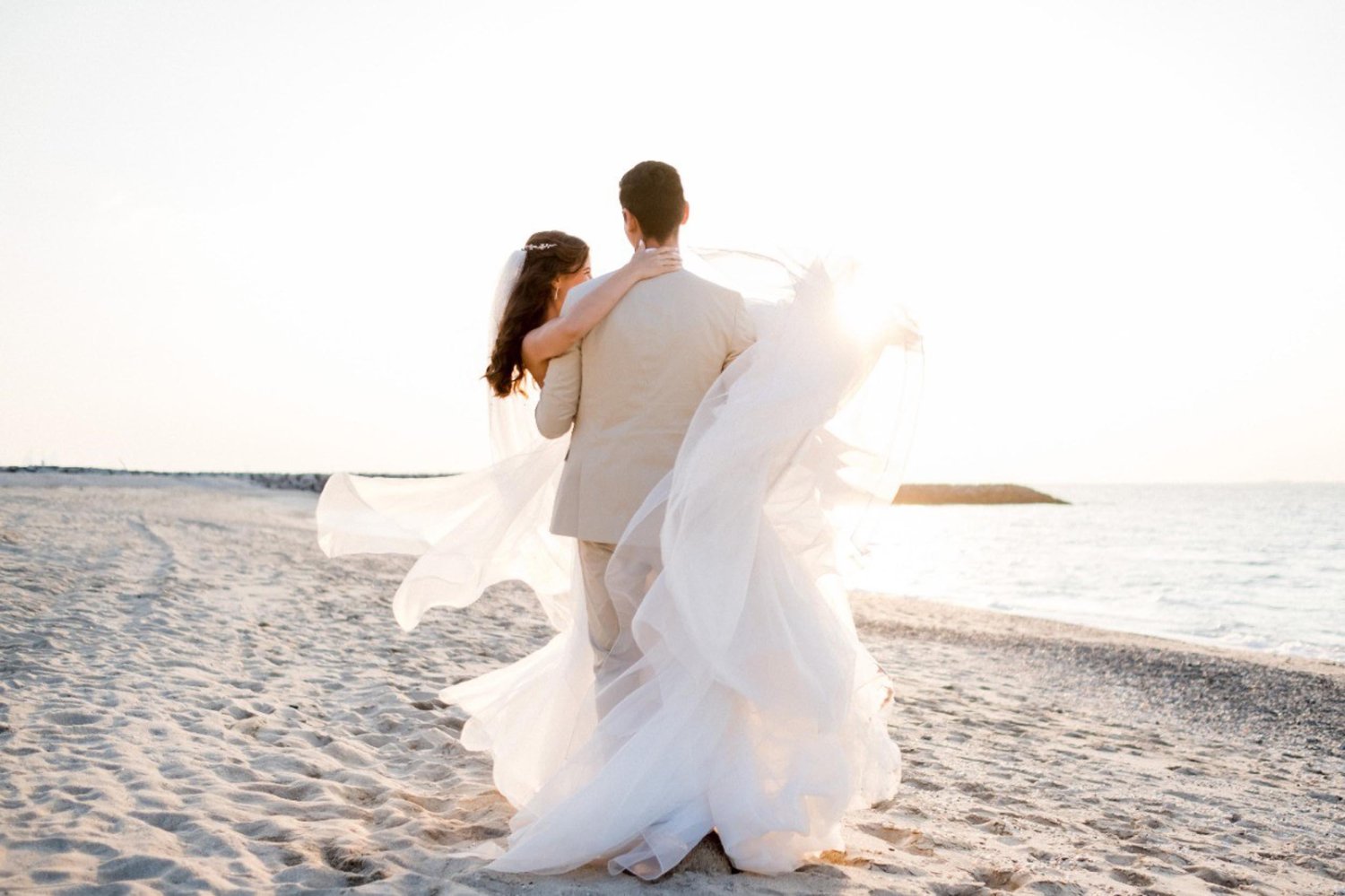A groom carrying his bride along the beach